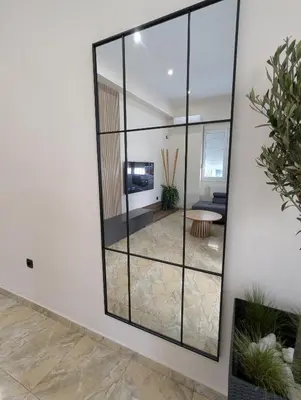 a mirror on a wall in a living room at Moda home 3siblings in Athens