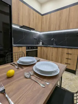 a wooden table with plates and utensils on it at Moda home 3siblings in Athens