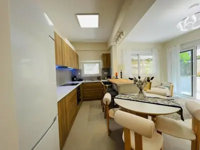 a kitchen with a table and chairs and a dining room at \u6d77\u98ce\u5c0f\u61a9 Seabreeze Haven in Athens