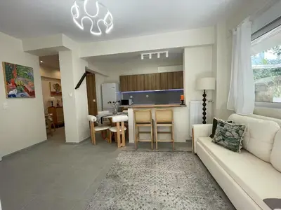 a living room with a white couch and a table at \u6d77\u98ce\u5c0f\u61a9 Seabreeze Haven in Athens