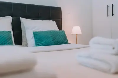 a bedroom with a large bed with green pillows at Coastal Charm Elegant 1BR at Marina Zea Piraeus in Piraeus