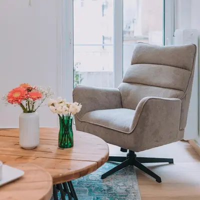 a living room with a chair and a wooden table at Coastal Charm Elegant 1BR at Marina Zea Piraeus in Piraeus