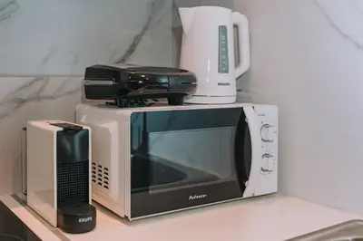 a microwave oven sitting on top of a counter at Coastal Charm Elegant 1BR at Marina Zea Piraeus in Piraeus