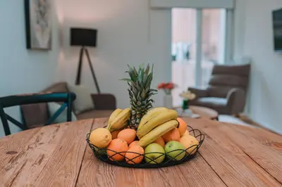 a bowl of fruit on a wooden table at Coastal Charm Elegant 1BR at Marina Zea Piraeus in Piraeus