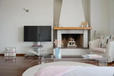 a living room with a fireplace and a tv at LaGon Luxury Villa in Foinikiá
