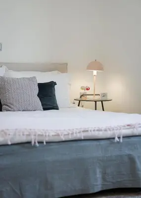 a bedroom with a large white bed with a side table at LaGon Luxury Villa in Foinikiá