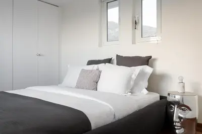 a bedroom with a bed with white sheets and pillows at LaGon Luxury Villa in Foinikiá