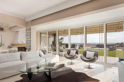 a living room with a white couch and chairs at LaGon Luxury Villa in Foinikiá