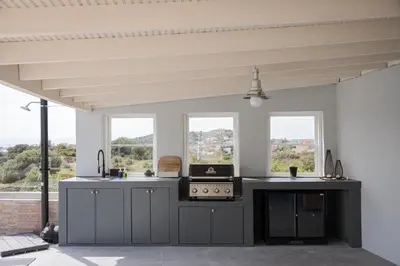 a kitchen with gray counters and windows and a stove at LaGon Luxury Villa in Foinikiá