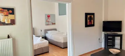 a bedroom with two beds and a mirror at Lovely apartment in Acropolis museum in Athens