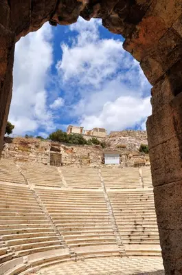 an amphitheatre seen through an opening in the ruins at Lovely apartment in Acropolis museum in Athens