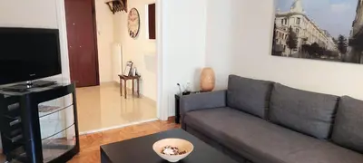 a living room with a couch and a television at Lovely apartment in Acropolis museum in Athens