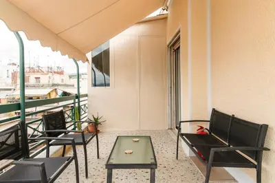 a balcony with chairs and a table on a building at Cosy Apartment in the Heart of Athens in Athens