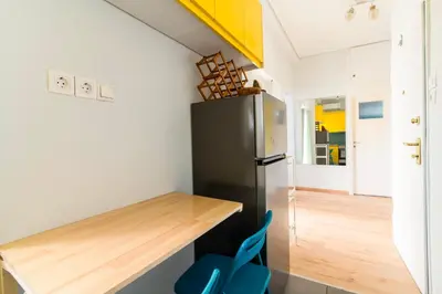 a kitchen with a black refrigerator and a wooden table at Cosy Apartment in the Heart of Athens in Athens