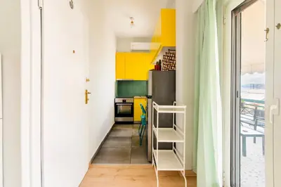 a kitchen with yellow and white walls and a refrigerator at Cosy Apartment in the Heart of Athens in Athens