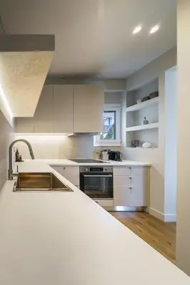 a kitchen with white cabinets and a sink at The Seafront Niche in Athens