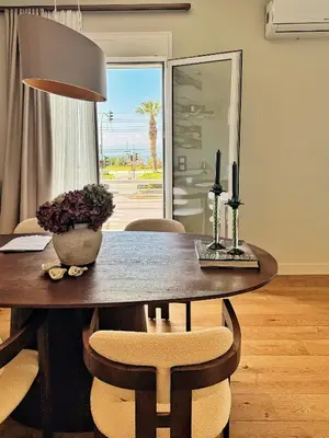 a dining room table with chairs and a table with a lamp at The Seafront Niche in Athens
