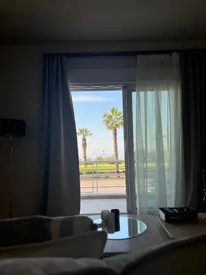 a room with a window with a view of a palm tree at The Seafront Niche in Athens