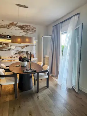 a dining room with a table and chairs and a room with a window at The Seafront Niche in Athens