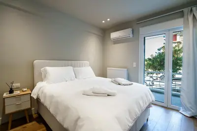a bedroom with a large white bed and a window at The Seafront Niche in Athens