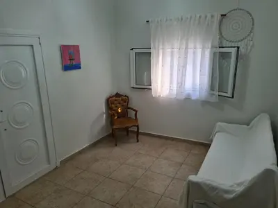 a room with a bed and a chair and a window at Sea View Hill House in Porto Rafti