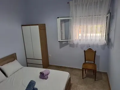 a bedroom with a bed and a chair and a window at Sea View Hill House in Porto Rafti