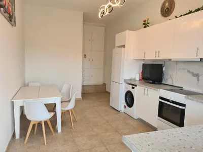 a kitchen with white cabinets and a table and chairs at Sea View Hill House in Porto Rafti