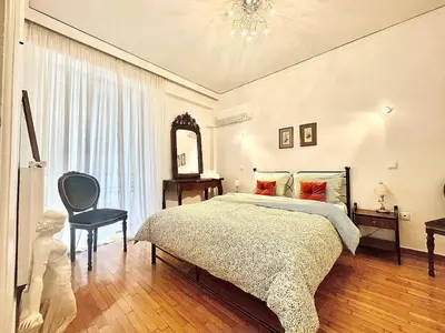a bedroom with a large bed and a chair at Zen house in Athenian Riviera in Athens