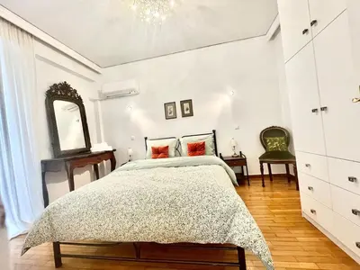 a bedroom with a bed and a mirror and a chair at Zen house in Athenian Riviera in Athens