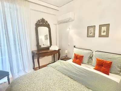 a bedroom with a bed with orange pillows and a mirror at Zen house in Athenian Riviera in Athens