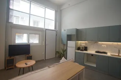 a kitchen with gray cabinets and a table in a room at Cozy Apartment Downtown Athens III in Athens