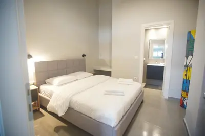 a bedroom with a white bed and a bathroom at Cozy Apartment Downtown Athens III in Athens