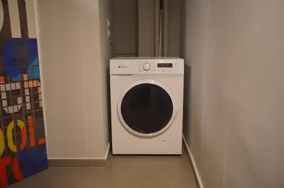 a washer and dryer in a corner of a room at Cozy Apartment Downtown Athens III in Athens