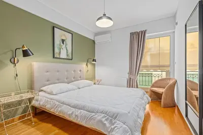 a bedroom with a large white bed and a window at Athens Acropolis Apartment in Athens