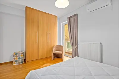a bedroom with a bed and a chair and a window at Athens Acropolis Apartment in Athens