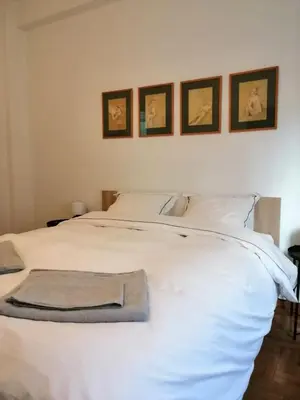 a bedroom with a white bed with four pictures on the wall at Kipseli Dreams Stylish Apt, AC, WiFi in Athens
