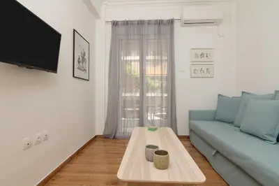 a living room with a blue couch and a coffee table at Kipseli Dreams Stylish Apt, AC, WiFi in Athens