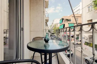 a table on a balcony with a view of a street at Kipseli Dreams Stylish Apt, AC, WiFi in Athens