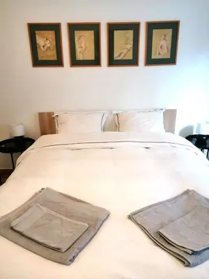a white bed with three pictures on the wall at Kipseli Dreams Stylish Apt, AC, WiFi in Athens