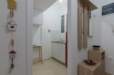 a kitchen with white cabinets and a table in a room at Kipseli Dreams Stylish Apt, AC, WiFi in Athens
