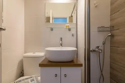 a bathroom with a sink and a toilet and a shower at Kipseli Dreams Stylish Apt, AC, WiFi in Athens