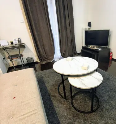 a room with a table and two chairs and a tv at Piraeus City Center Apartment Port & Metro Dimotiko theatro in Piraeus