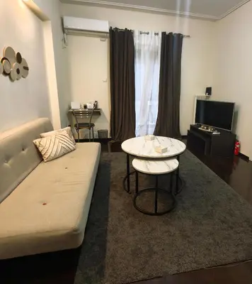 a living room with a couch and a table at Piraeus City Center Apartment Port & Metro Dimotiko theatro in Piraeus