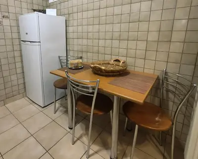 a kitchen with a table with chairs and a refrigerator at Piraeus City Center Apartment Port & Metro Dimotiko theatro in Piraeus