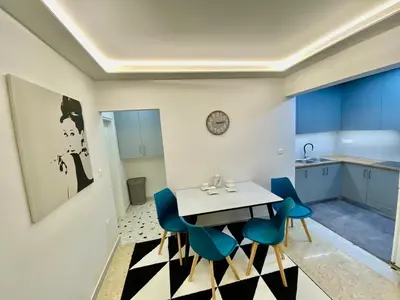 a dining room with a table and blue chairs at 4 Cups of Mint Tea in Athens