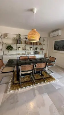 a dining room with a black table and chairs at Retro Chic 1 BR 1 Min to Sea in Athens
