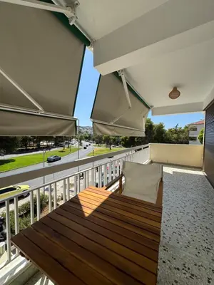 a balcony with a wooden bench and a view of a street at Retro Chic 1 BR 1 Min to Sea in Athens