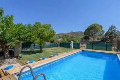 a swimming pool in a yard with chairs and trees at Petrino pool house in Athens