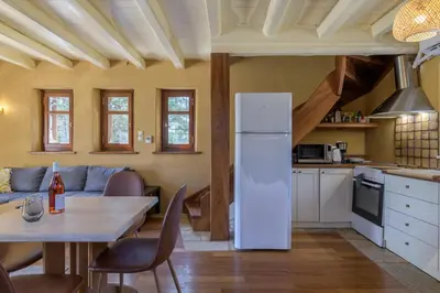 a kitchen and dining room with a white refrigerator at Petrino pool house in Athens