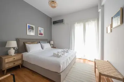 a bedroom with a large white bed and a window at Zen Palm, Exarchia in Athens